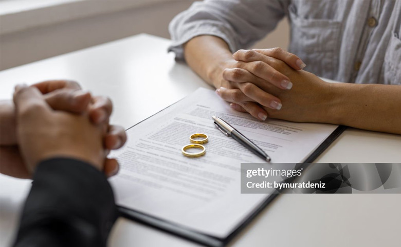 couple going over divorce papers with wedding rings on document